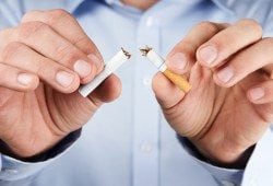 Quit smoking concept of man tearing cigarette in half